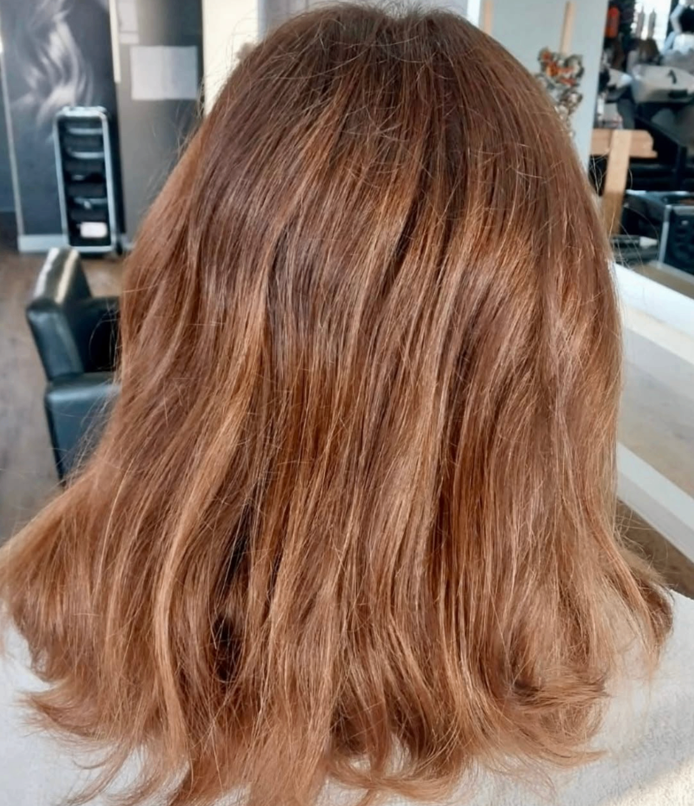 Glossy caramel-brown mid-length waves at Liv Hair Studio